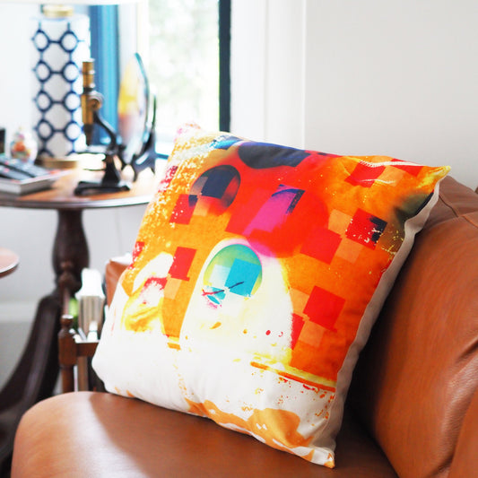 Colorful pillow with abstract design on a brown chair