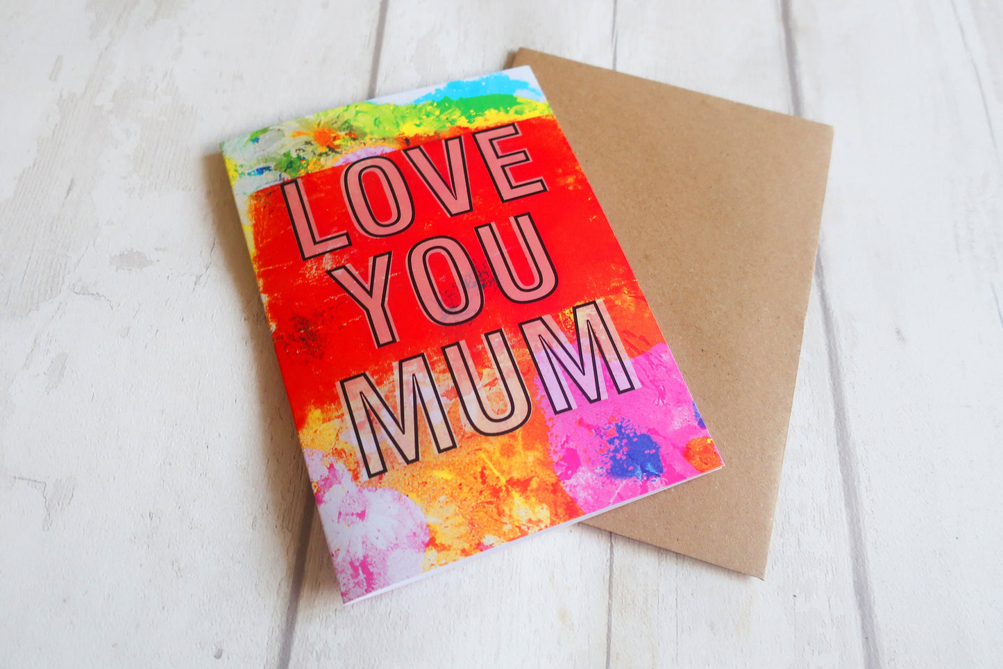 Colorful card with 'LOVE YOU MUM' text on a white surface