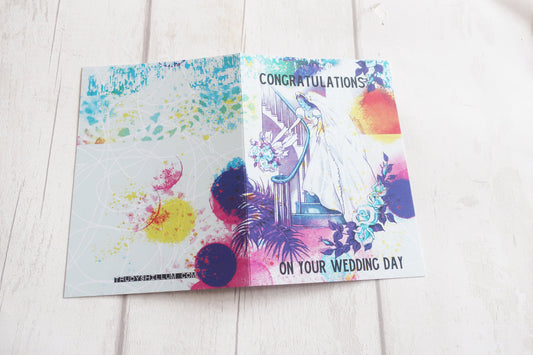 Colorful wedding card with watercolor design on a white wooden surface