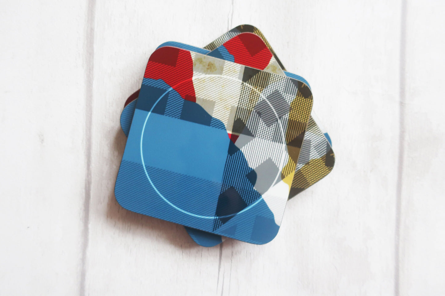 Set of colorful coasters on a white wooden surface