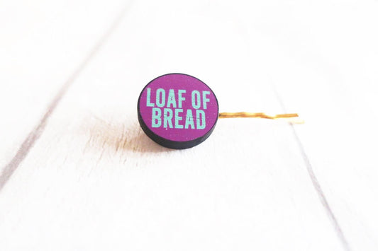 Purple hairclip with 'LOAF OF BREAD' text on a white background