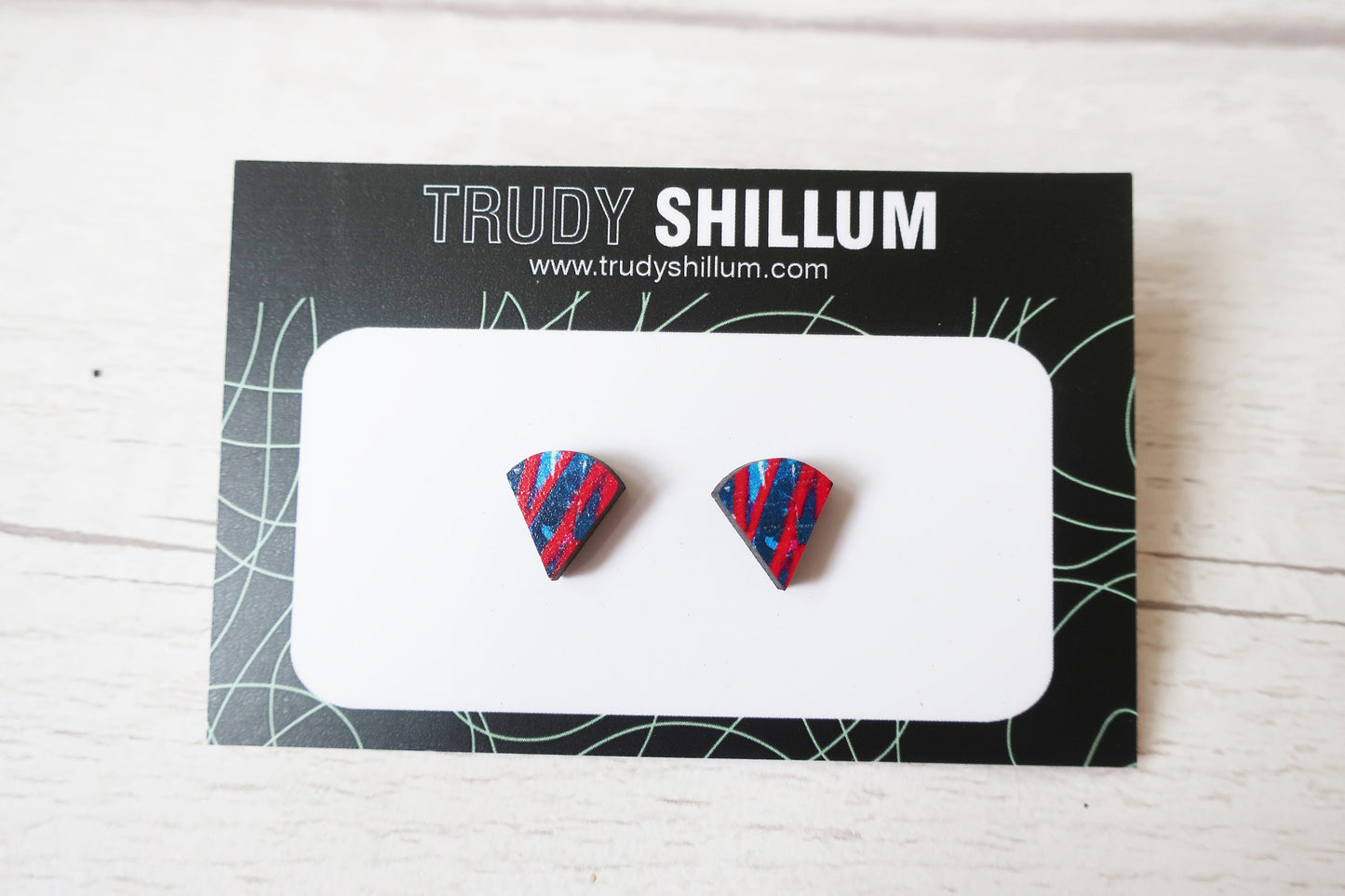Pair of colorful geometric earrings on a Trudy Shillum branded card.