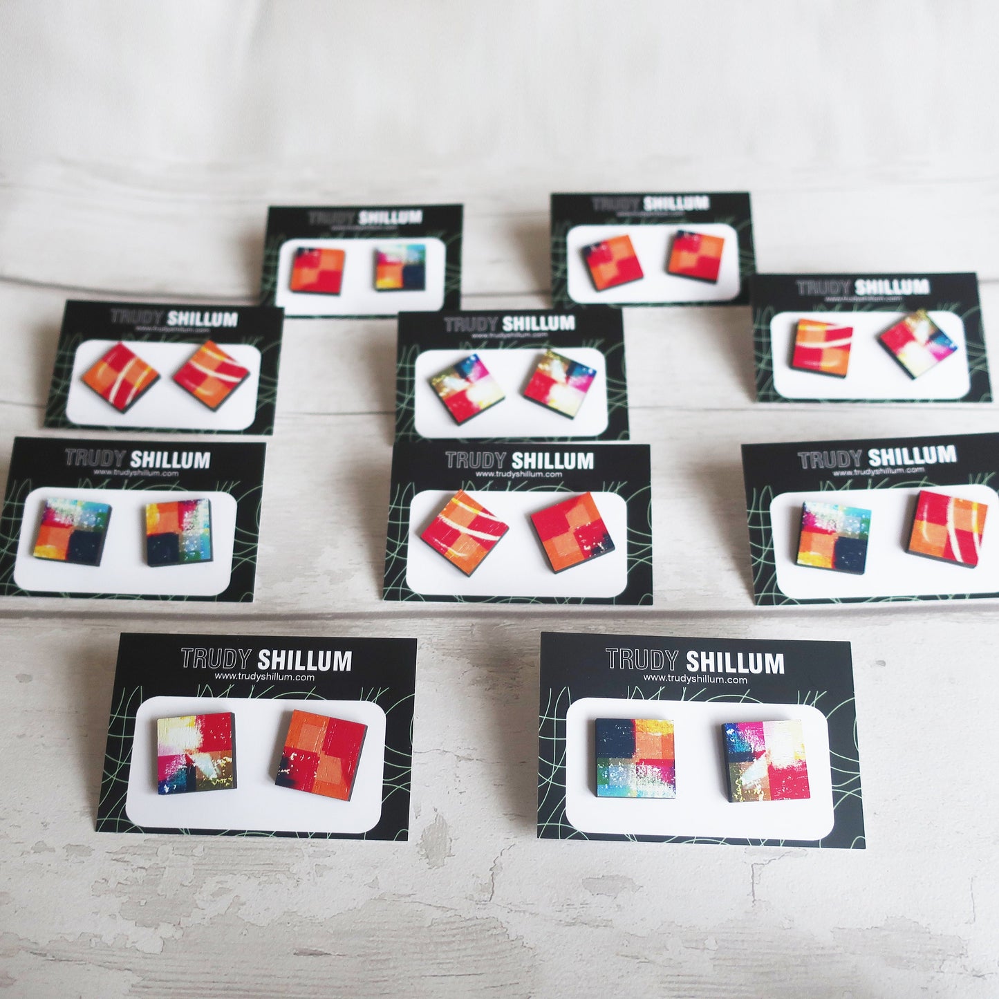 Multiple boxes of Trudy Shillum jewelry on a light wooden surface