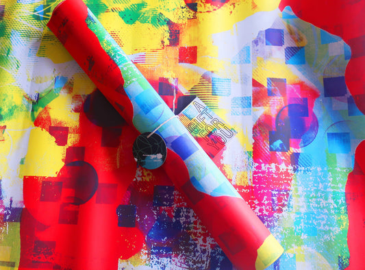 Colorful wrapping paper with a roll of paper and red fabric on a multicolored background
