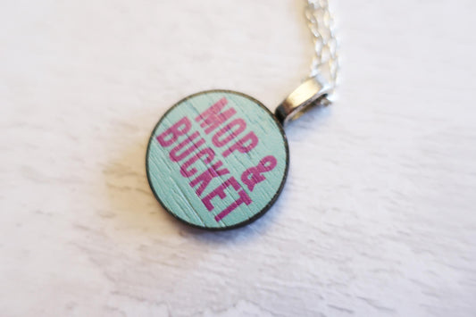 Round pendant necklace with 'Mop & Bucket' text on a light background