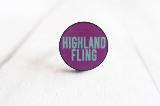 Round purple ring with 'Highland Fling' text on a white background