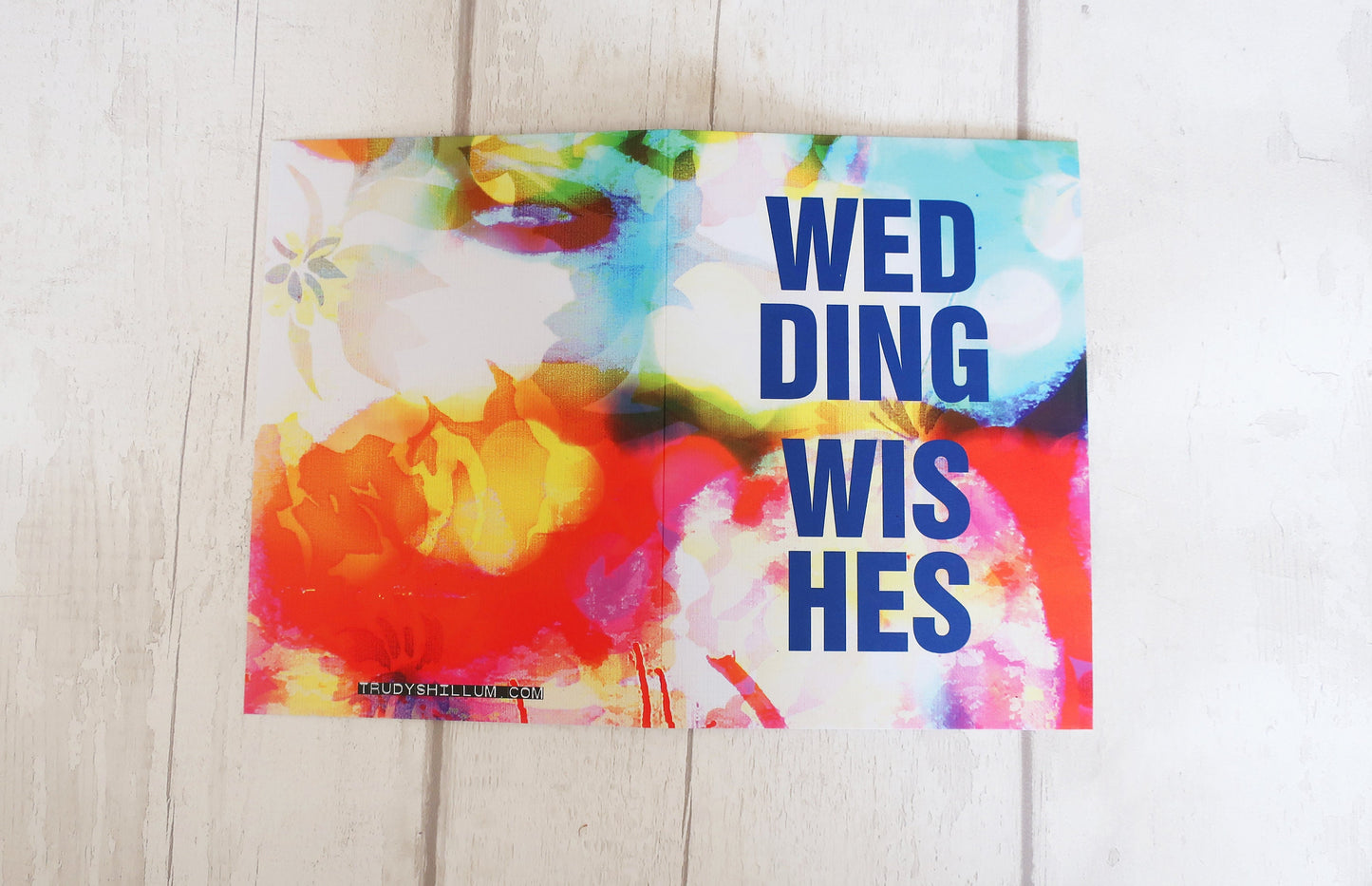 Colorful card with 'Wedding Wishes' text on a wooden surface