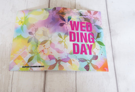 Colorful floral card with 'Wedding Day' text on a wooden surface