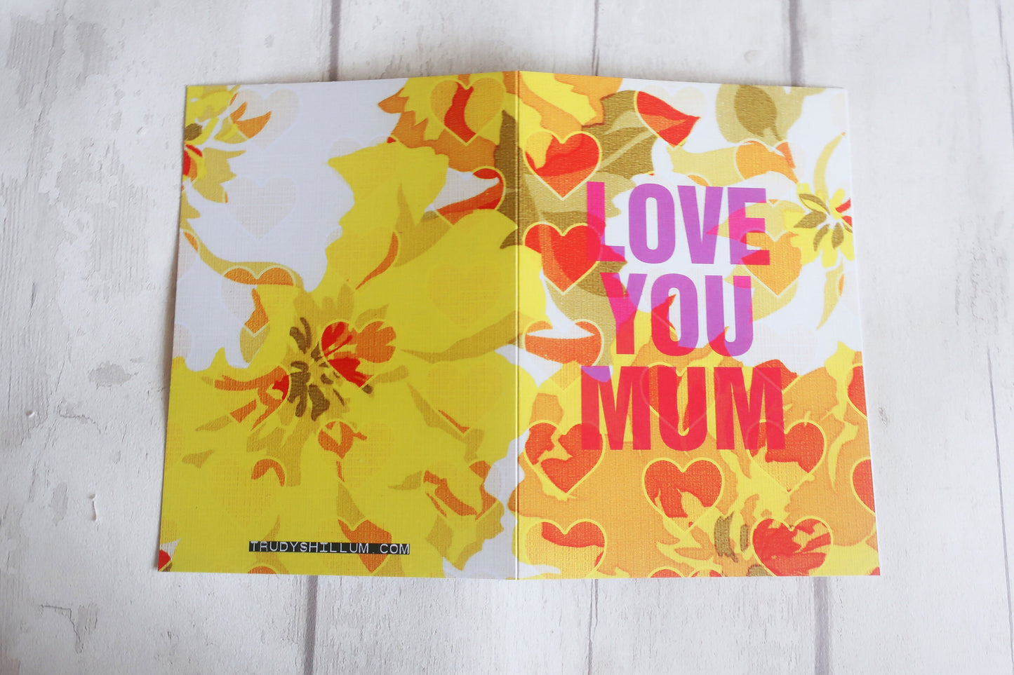 Floral card with 'LOVE YOU MUM' text on a light wooden surface