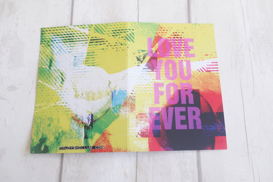 Colorful card with a dove and 'Love You Forever' text on a wooden surface