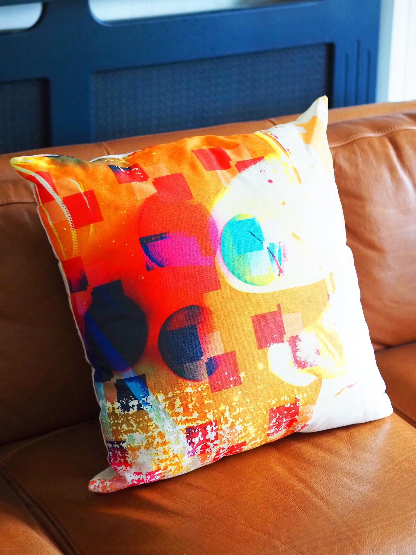 Colorful abstract-patterned pillow on a brown leather couch