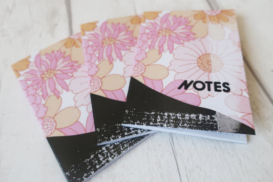 Floral notebook with 'NOTES' label on a light wooden surface