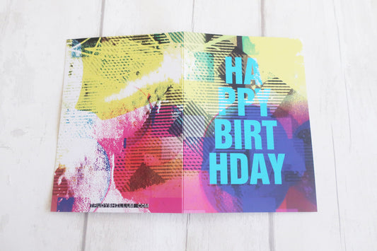 Colorful birthday card with abstract design on a white wooden surface