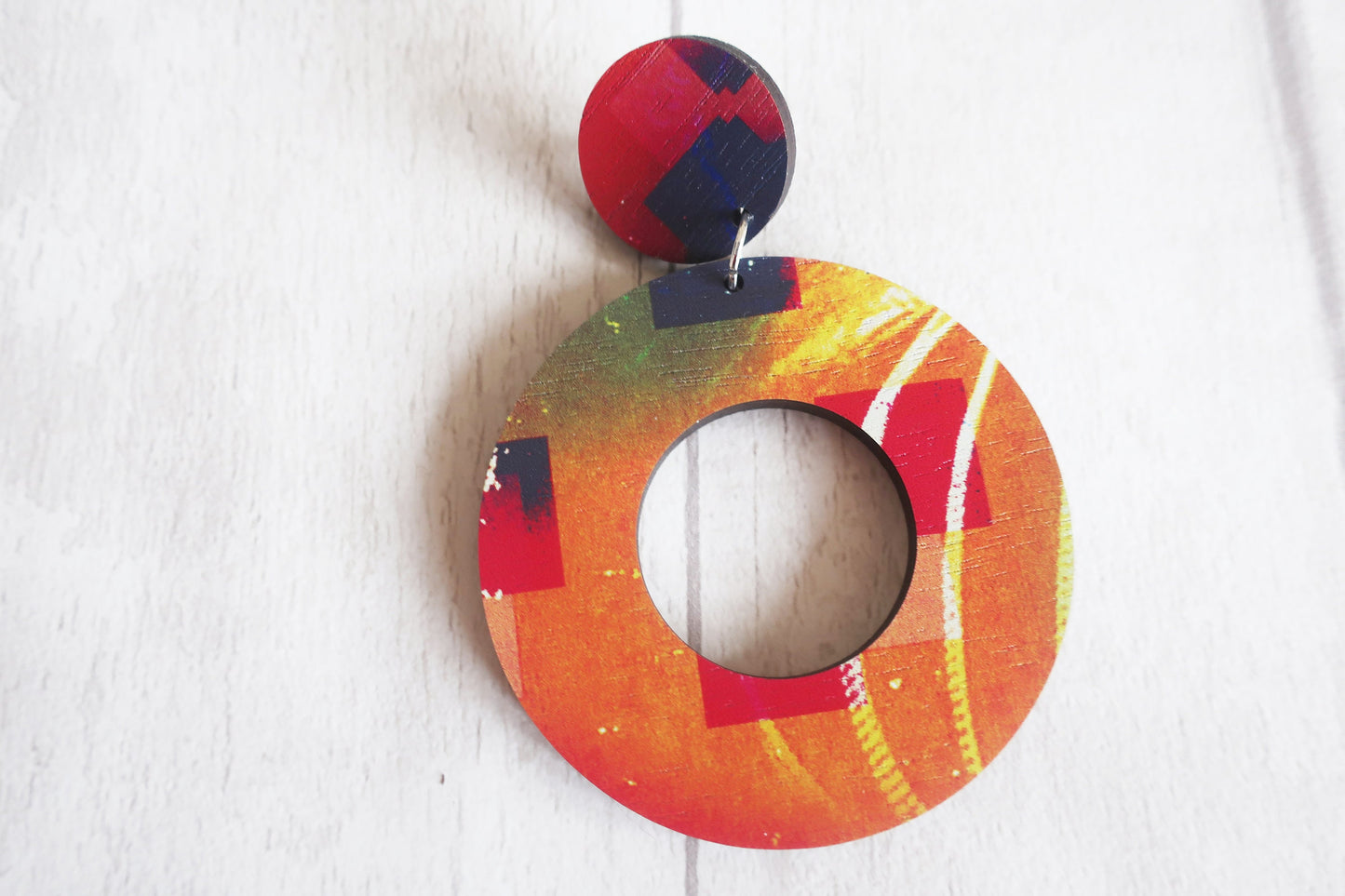 Colorful circular earring with a pattern on a white background