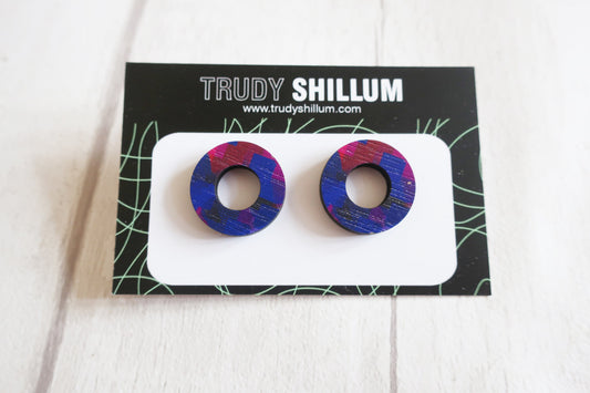 Pair of round earrings on a Trudy Shillum branded card against a white background