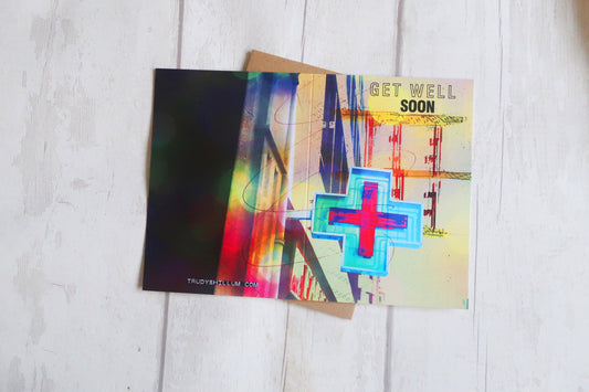 Colorful greeting card with a cross symbol on a white wooden surface