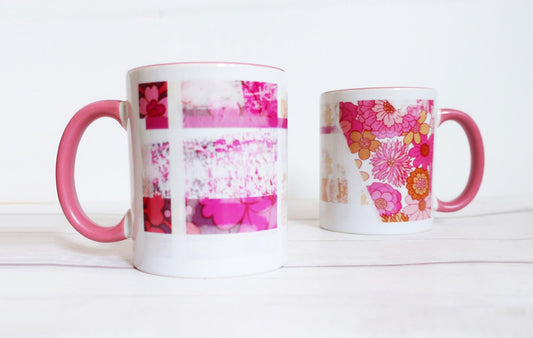 Two mugs with pink and floral designs on a white surface