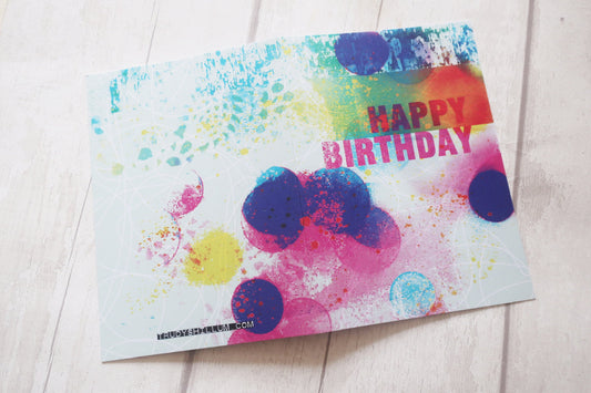 Colorful birthday card with polka dots on a light wooden surface