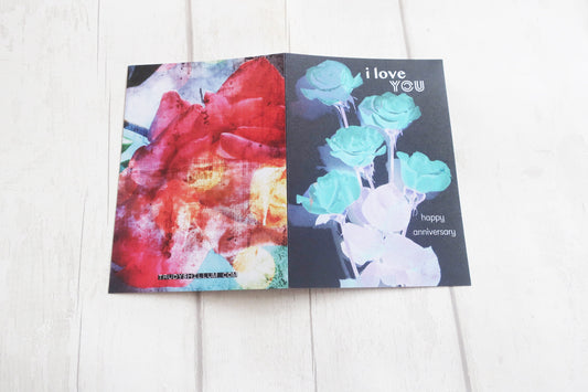 Greeting card with floral design and 'I love you' text on a white wooden surface