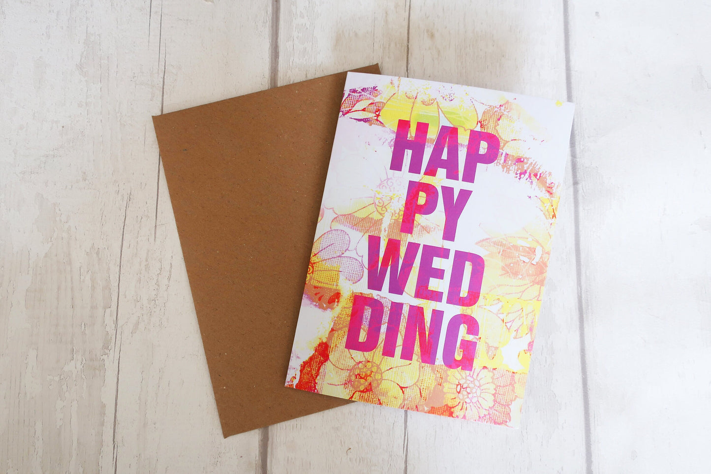 Greeting card with 'Happy Wedding' text on a wooden surface