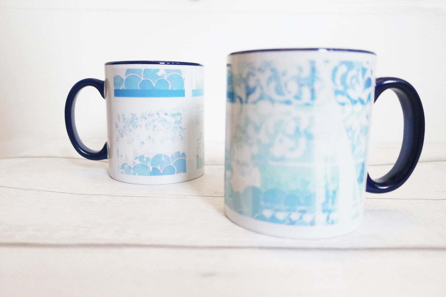 Two mugs with blue and white pattern on a white surface