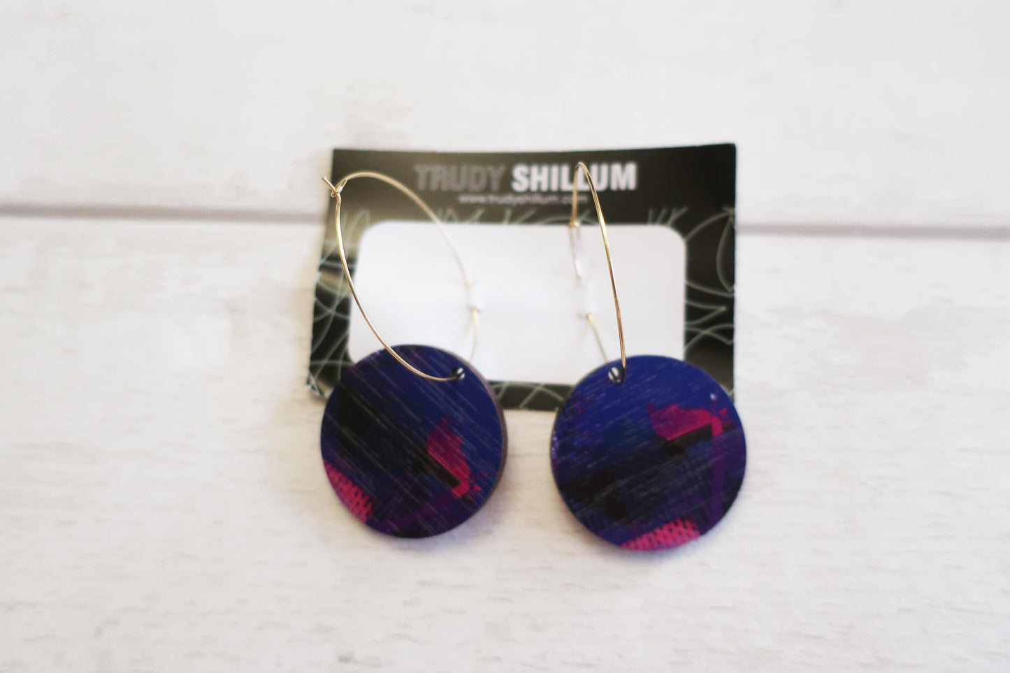 Pair of blue earrings with pink accents on a Trudy Shillum branded card.