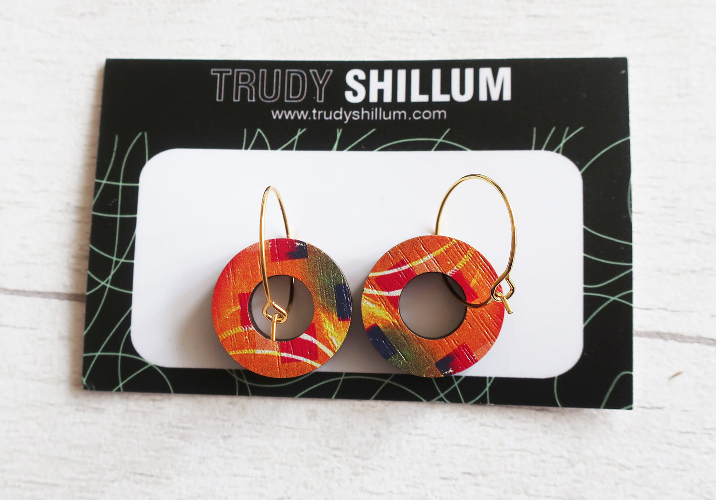 Colorful hoop earrings on a Trudy Shillum branded card.