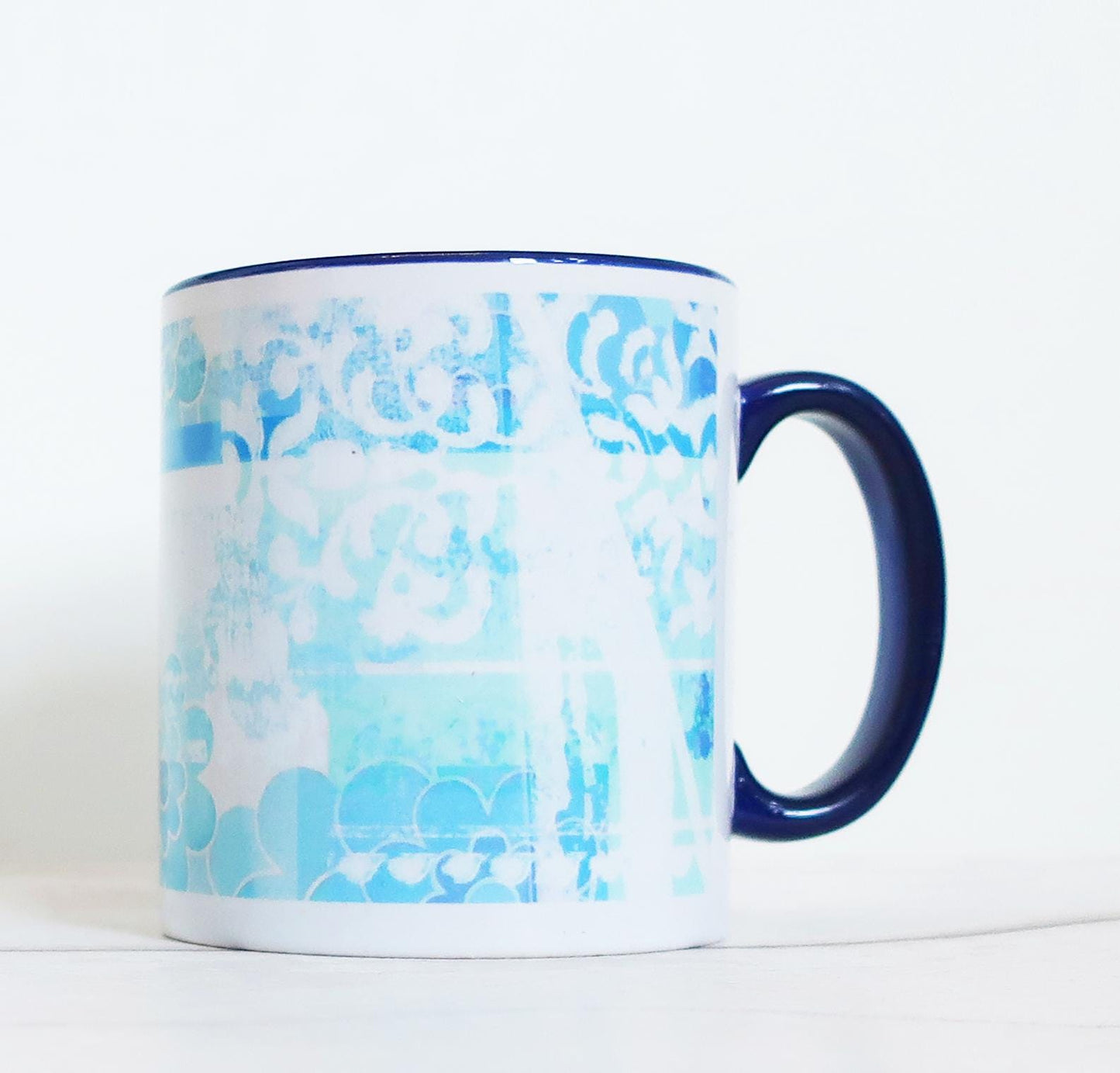 Mug with blue floral pattern and navy handle on a white background