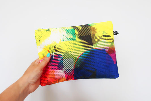 Colorful pouch held by a hand on a white background
