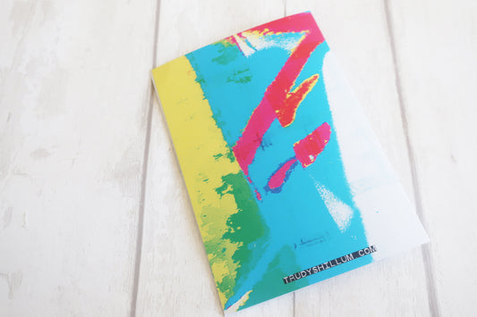 Colorful card back with abstract design on a white wooden surface