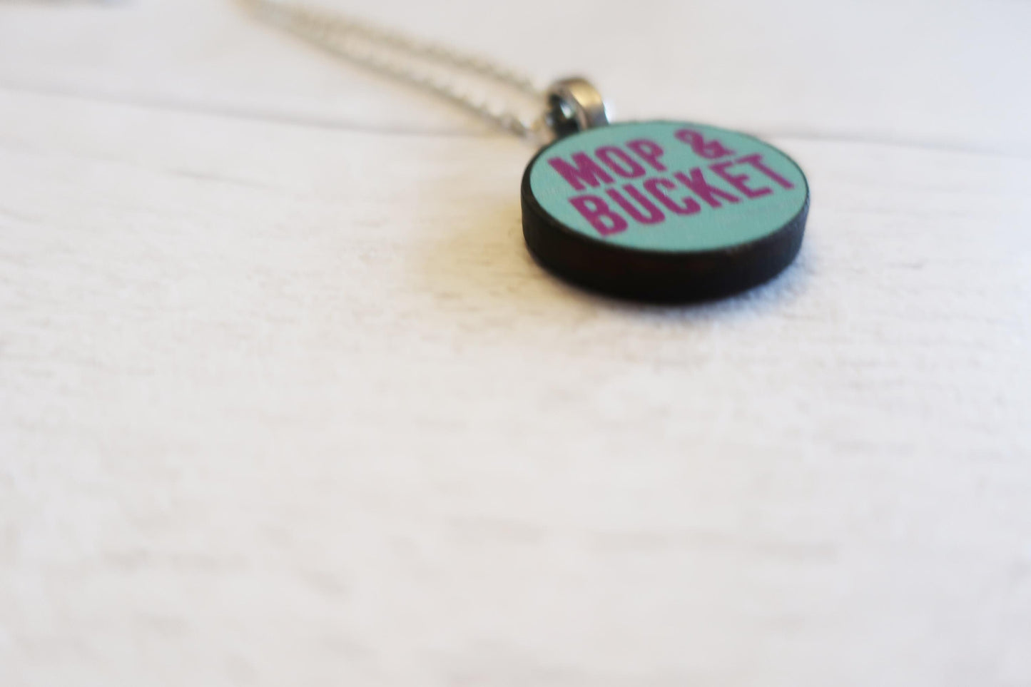 Necklace with a pendant labeled 'Mop & Bucket' on a white background