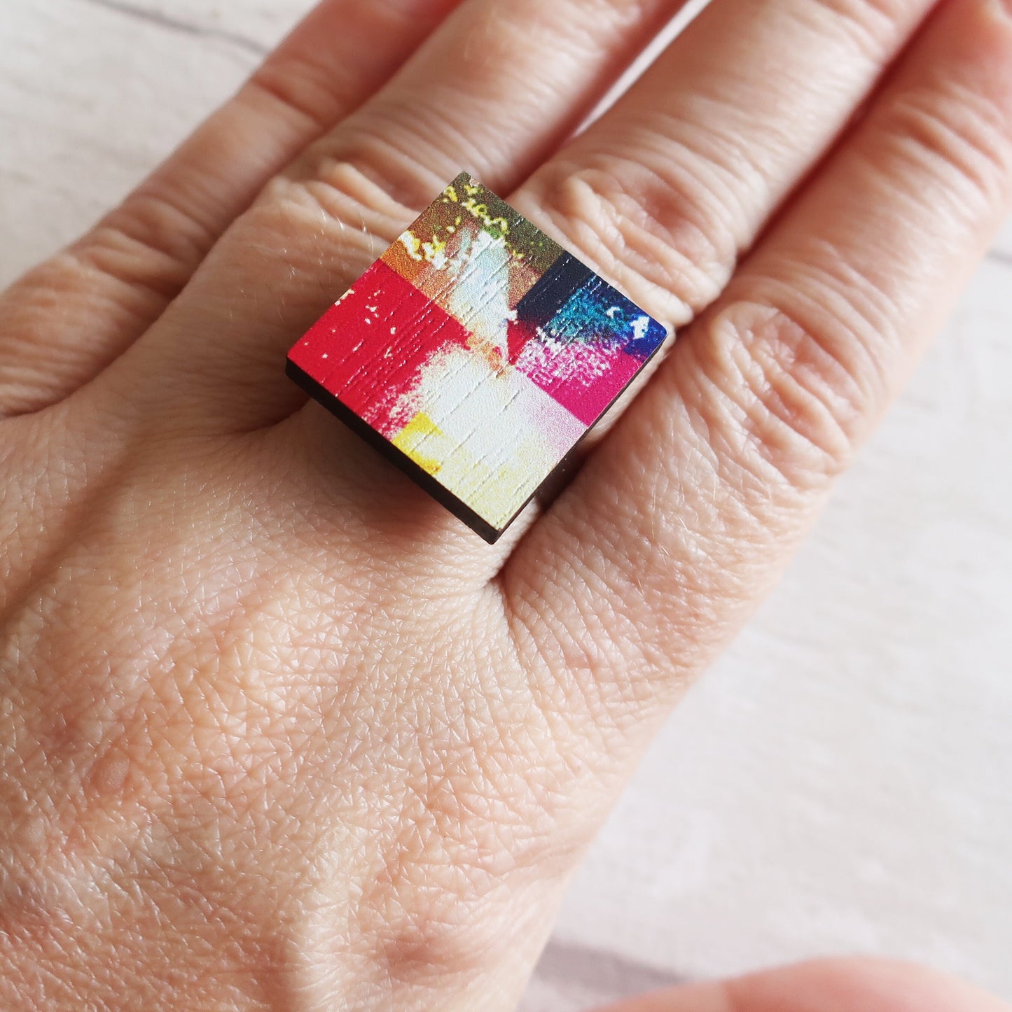 Colorful ring on a person's finger with a light background