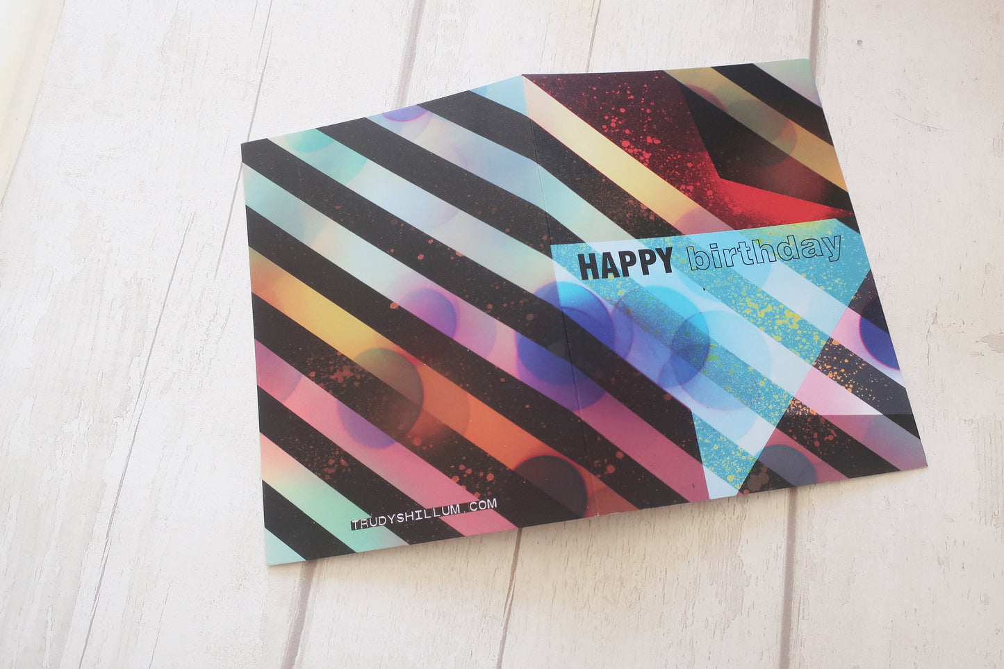 Colorful birthday card with geometric design on a light wooden surface