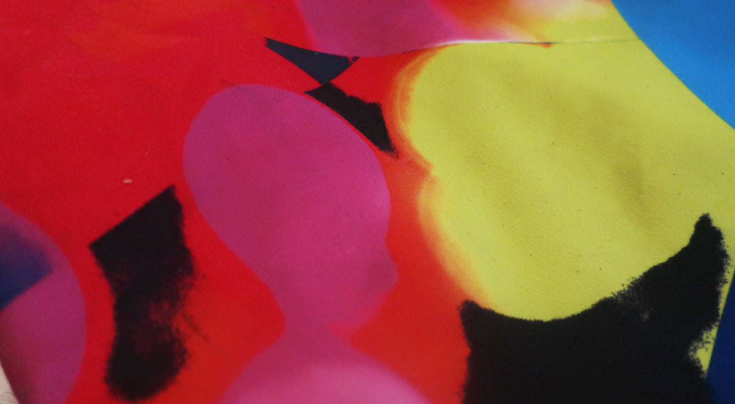 Abstract fabric with colorful shapes and a black cat silhouette on a red background