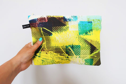 Colorful pouch with abstract design held by a hand against a white background