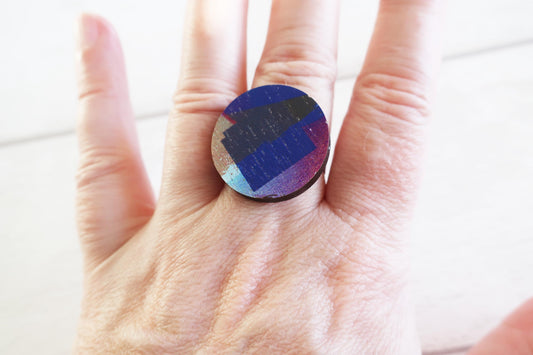 Hand wearing a colorful ring with a white background