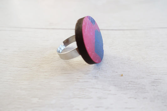Ring with pink and blue circular design on a white background