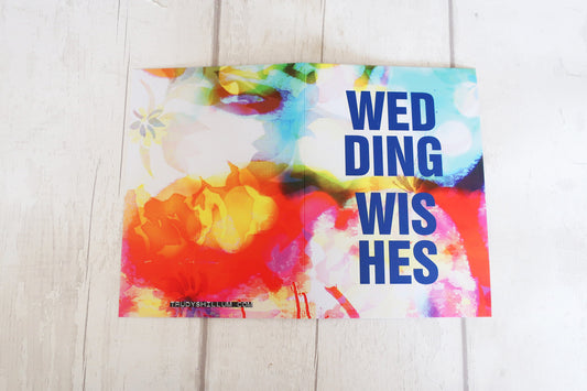 Colorful card with 'WEDDING WISHES' text on a wooden surface
