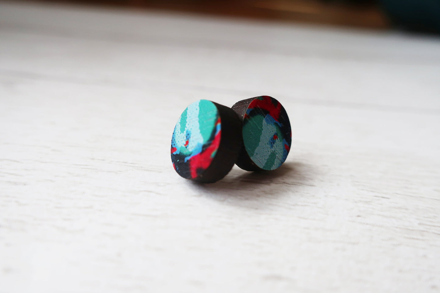 Colorful wooden earrings on a light surface