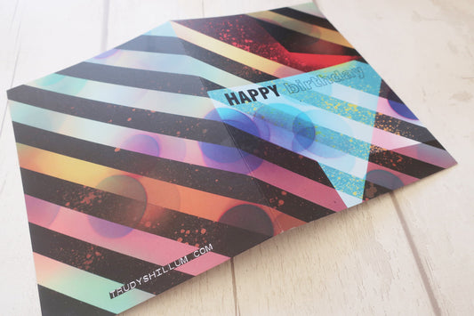Colorful birthday card with geometric design on a white surface