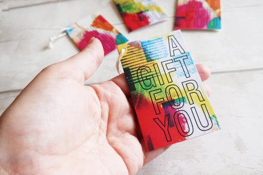 Colorful gift card held by a hand with more cards in the background