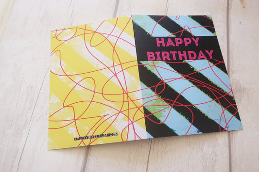 Colorful birthday card with geometric patterns on a wooden surface