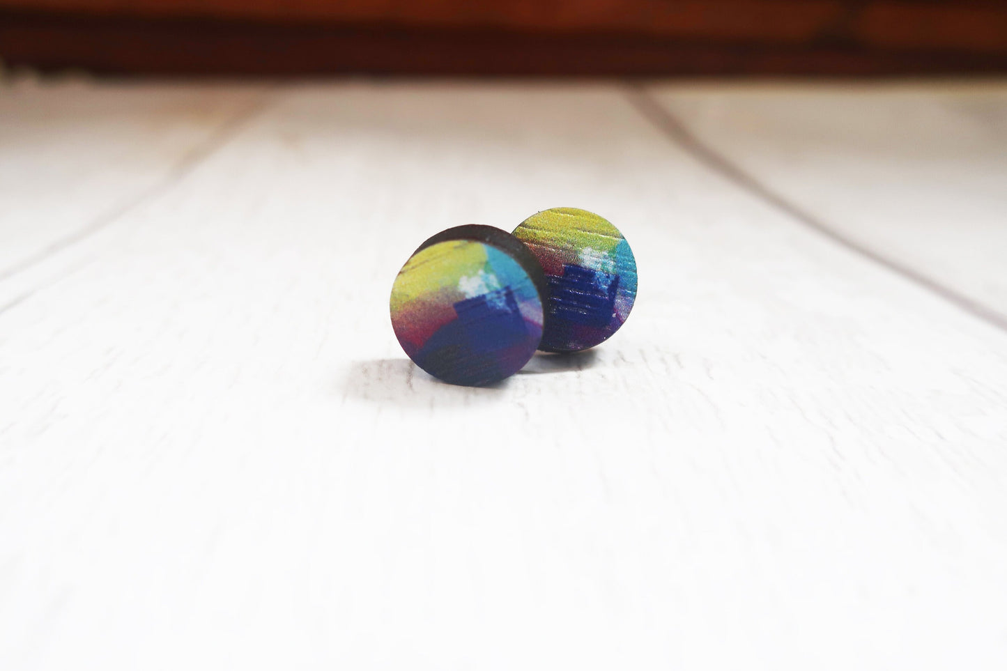 Multicolored wooden earrings on a light surface