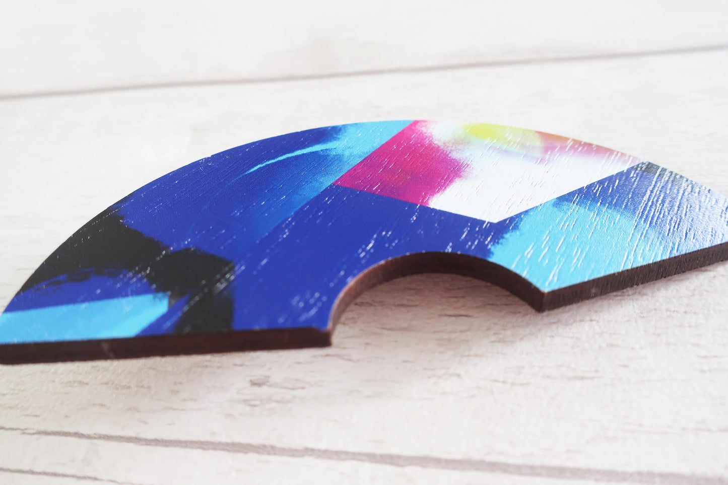 Colorful half-circle hairclip on a wooden surface