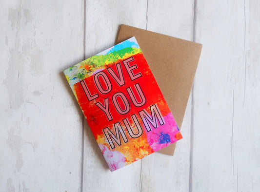 Colorful card with 'Love You Mum' text on a wooden surface