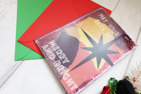 Holiday card with red envelope and decorative elements on a light surface