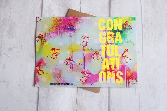 Colorful congratulation card with abstract design on a wooden surface