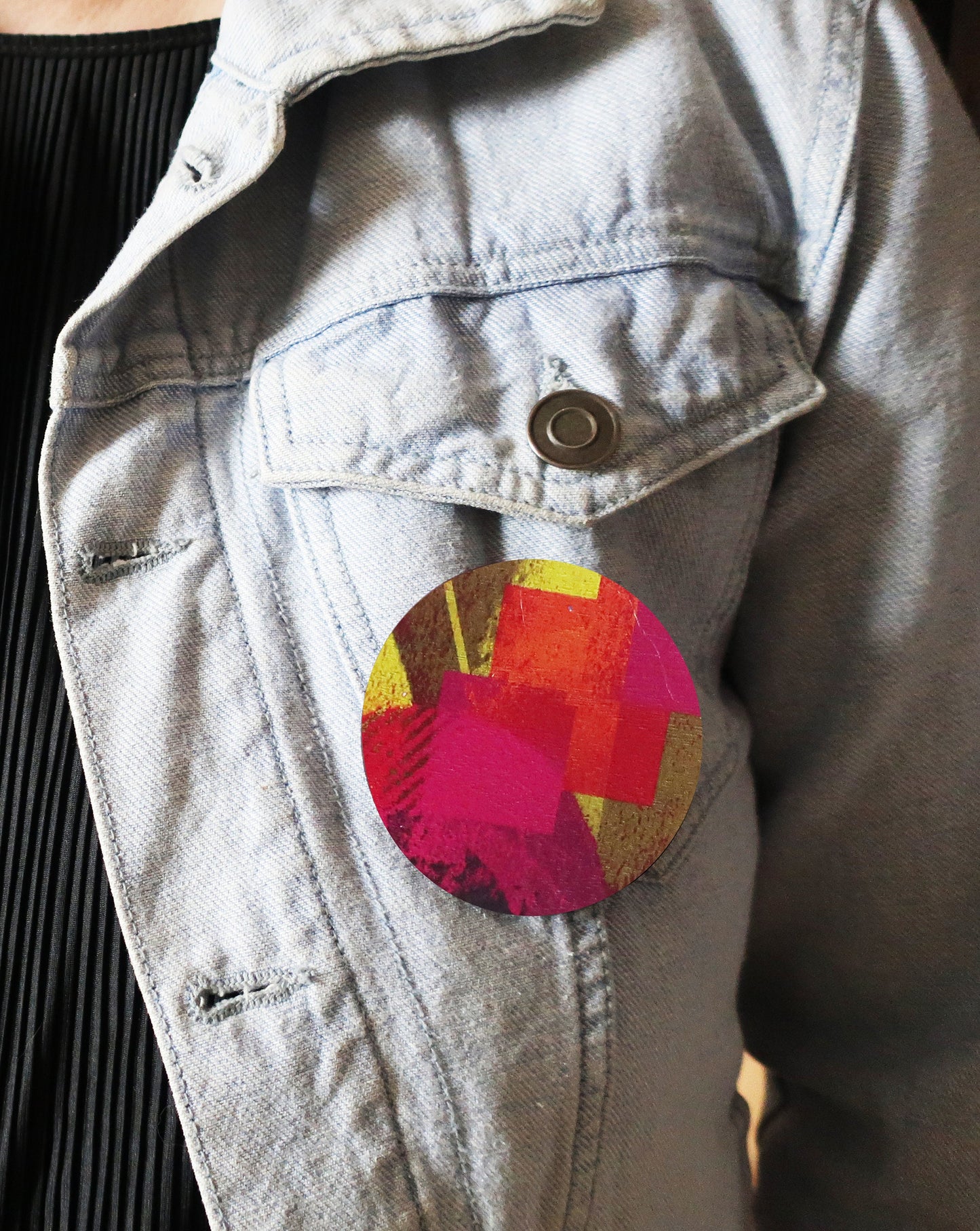 Colorful circular brooch on a denim jacket