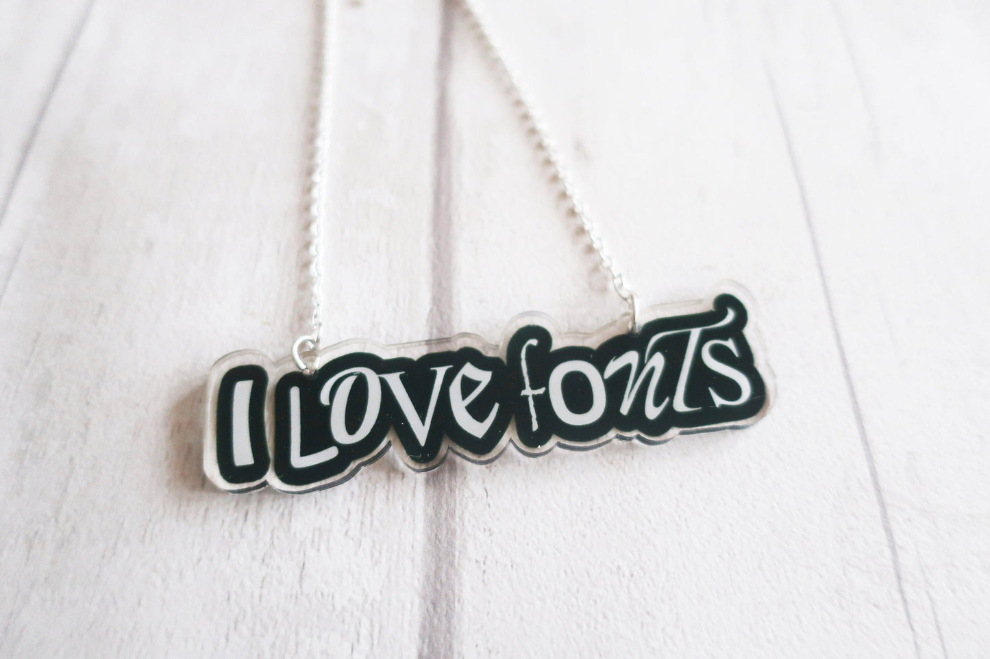 Necklace with 'I LOVE FONTS' pendant on a white background