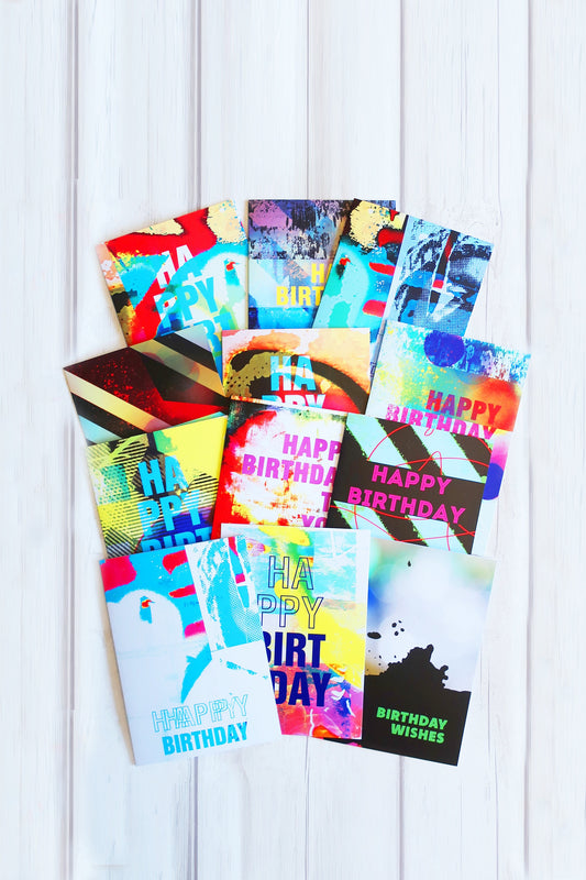 Collection of colorful birthday cards on a white wooden surface